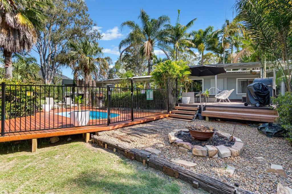 a backyard with a pool and a fence at Tamborine Palms Farmhouse in Tamborine