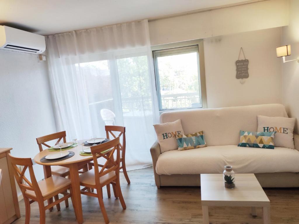- un salon avec un canapé et une table dans l'établissement tecy Pierre et vacances, à Sainte-Maxime