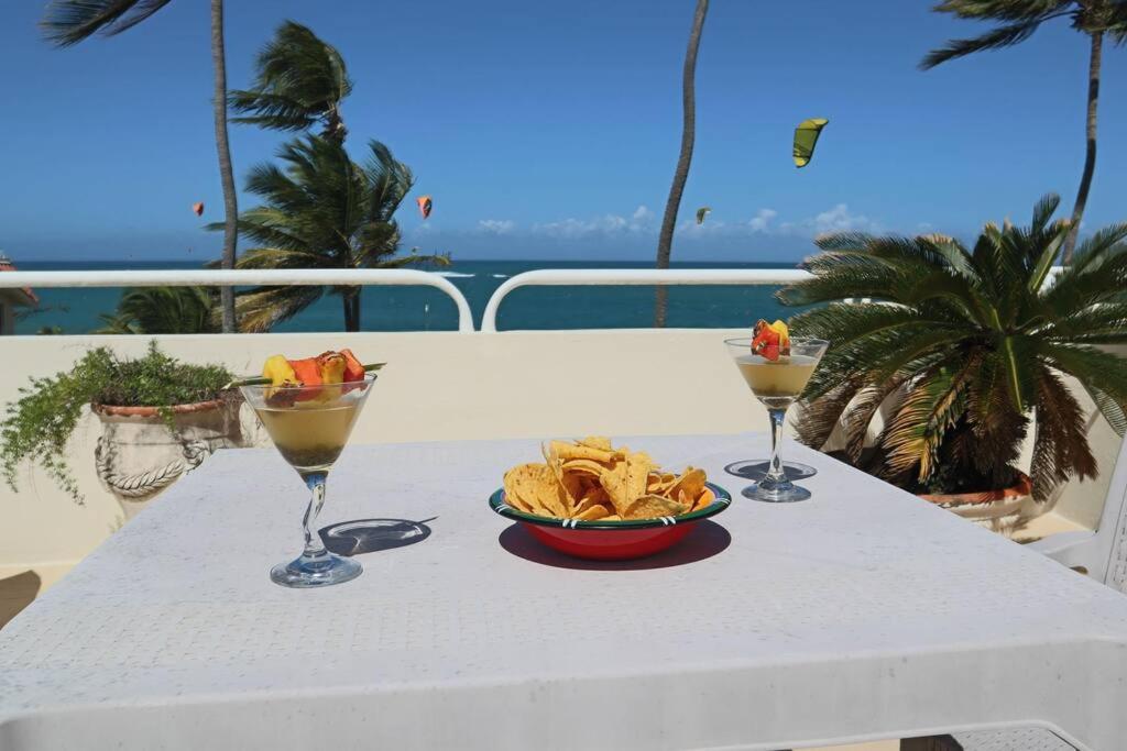 una mesa con un tazón de patatas y dos copas de vino en Nanny Estate Cabarete Beachfront Condos Unit A2, en Cabarete