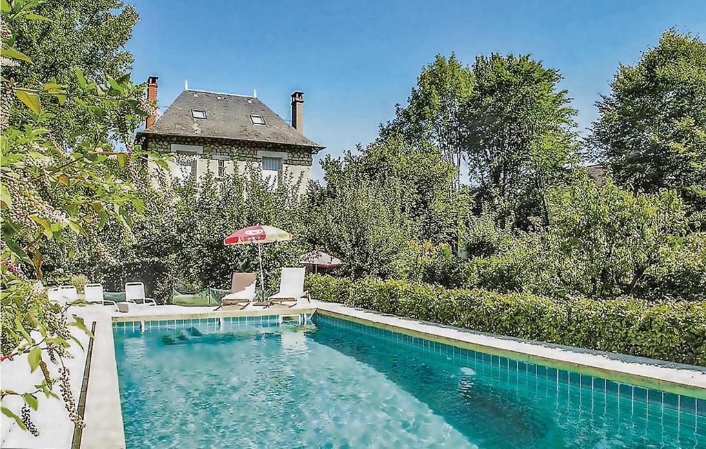una piscina con sillas, una sombrilla y una casa en Beautiful Home In Terrasson-lavilledieu With Wifi en Terrasson
