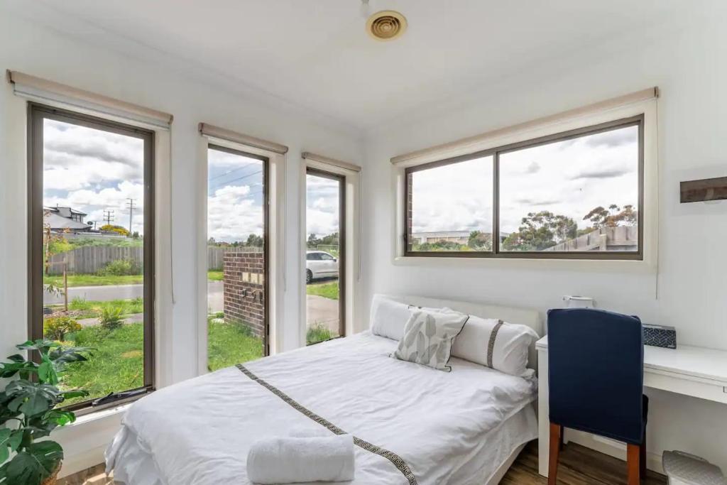 una camera con letto, scrivania e finestre di Melbourne Lovely Nest a Melbourne