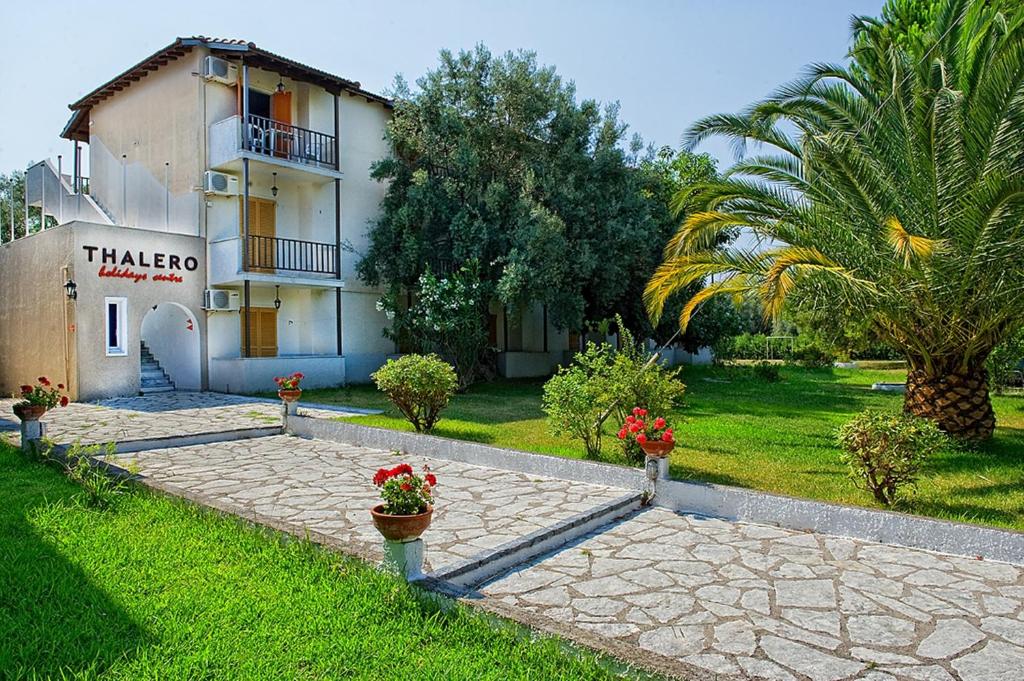 a building with a palm tree and a walkway at Thalero Holidays Center in Lygia