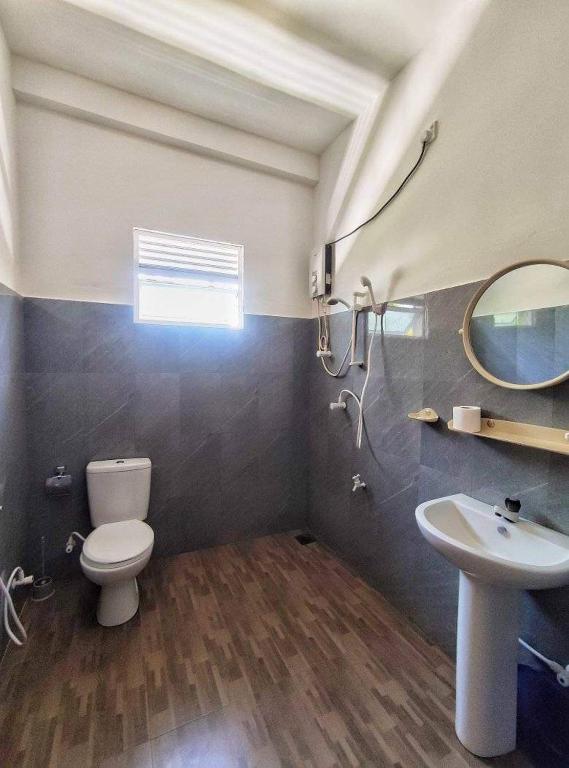 un bagno con un water, un lavandino e uno specchio di SunRay Rest - Beach View Homestay a Mirissa