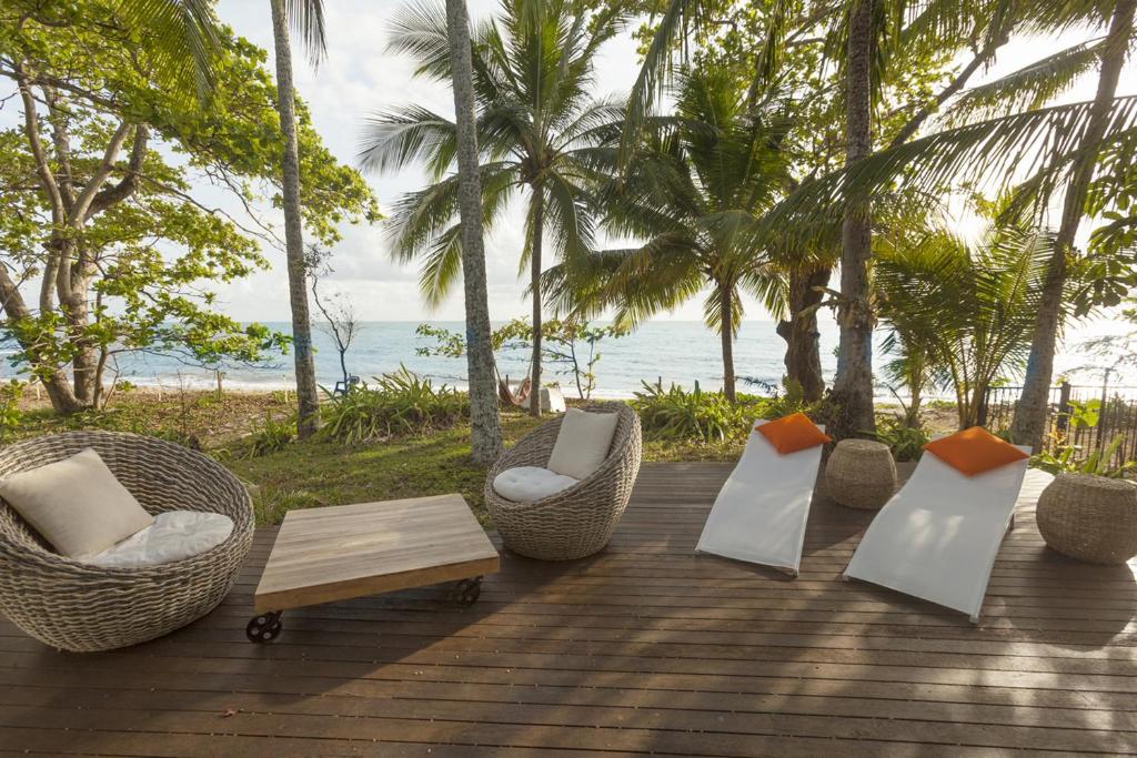 a group of chairs and a coffee table on a deck at Drift Beach House Getaway in Holloways Beach