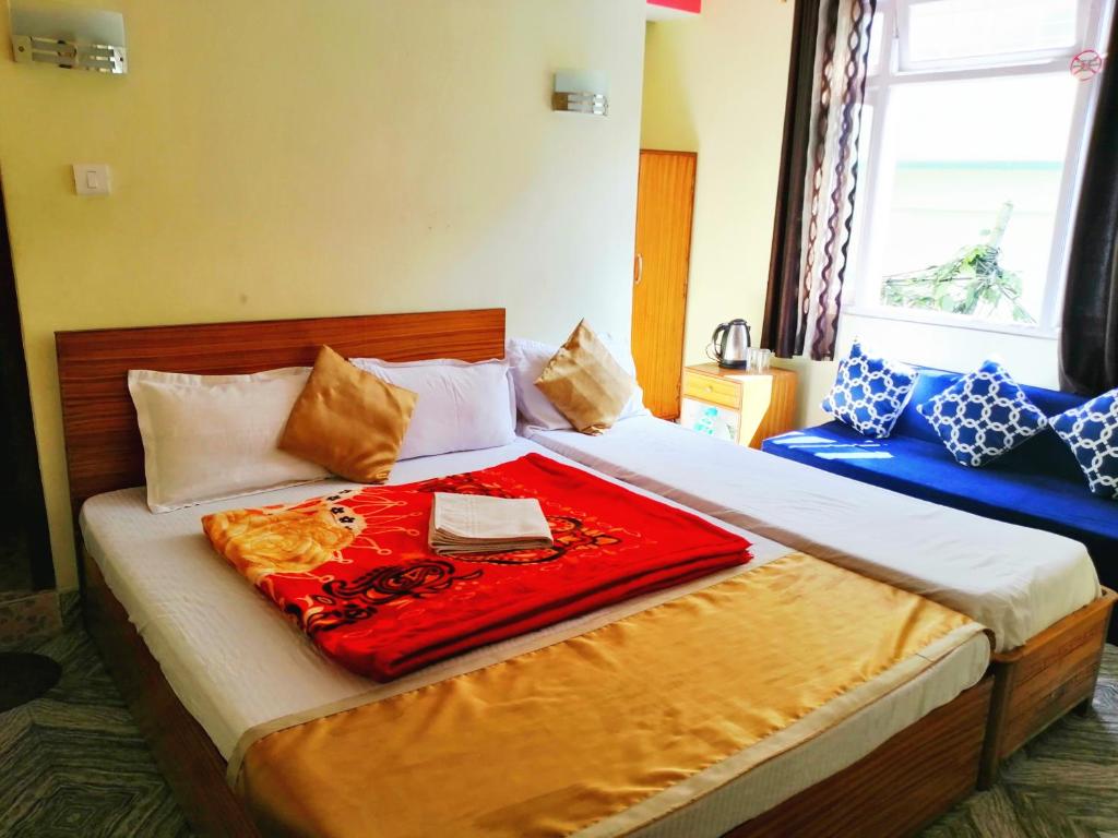 Una cama con una manta roja encima. en Hotel Nindik, en Gangtok
