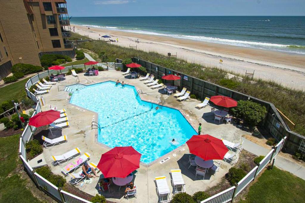 una vista aérea de una piscina con sombrillas y una playa en Sandy Topsail Dunes, en North Topsail Beach