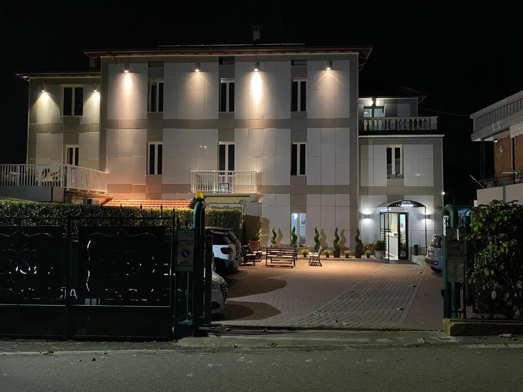 un gran edificio blanco con luces encendidas por la noche en Hotel La Quercia, en Mozzo