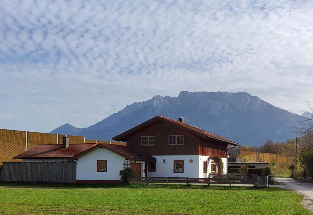 een huis in een veld met een berg op de achtergrond bij Ferienhaus Inntal in Oberaudorf