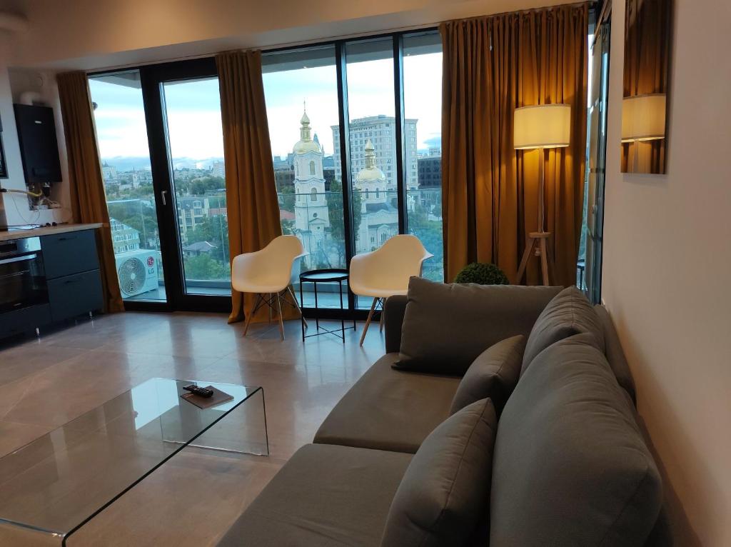 a living room with a couch and a large window at Sky City Panoramic in Iaşi