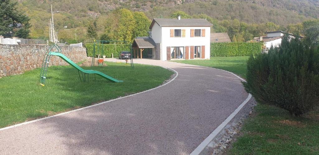 a playground with a slide in the grass next to a house at La Résidence de Lorelei in Cierp