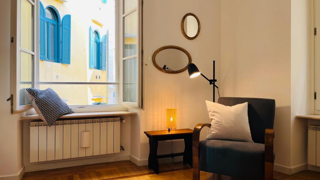 - un salon avec une chaise et une fenêtre dans l'établissement Casa Fonti Unità, à Trieste