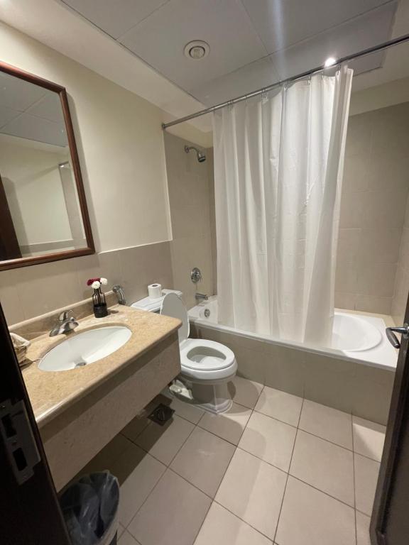 een badkamer met een wastafel, een toilet en een bad bij relax room in King Abdullah Economic City
