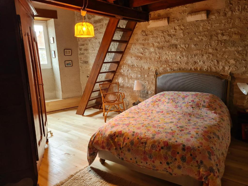 1 dormitorio con 1 cama en una pared de ladrillo en Maison du XVème au cœur du village médiéval, en Martel