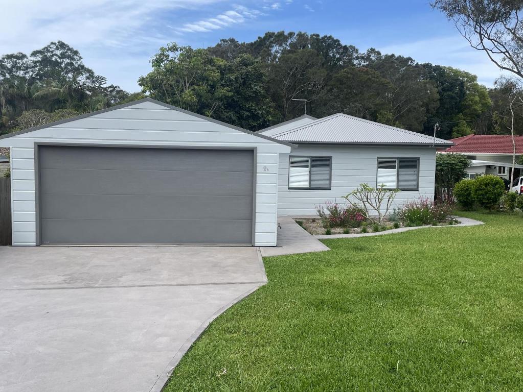 a house with a garage at Walk to Flynns , Nobbys Beach - Tranquility amongst the Rainforest in Port Macquarie