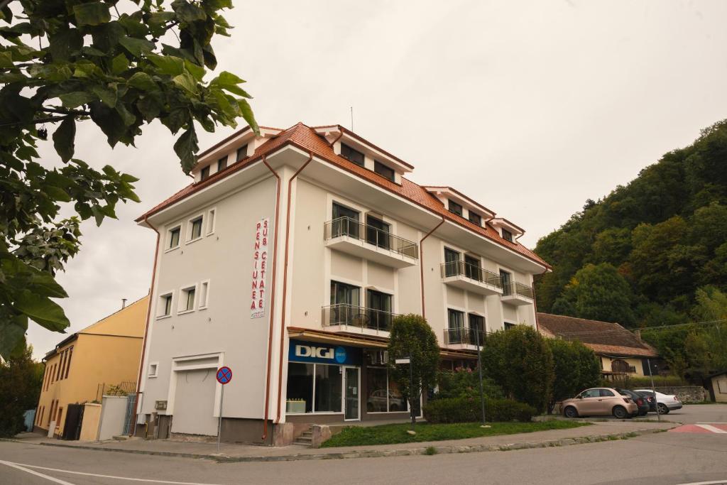 un grand bâtiment blanc au coin d'une rue dans l'établissement Sub Cetate, à Râșnov