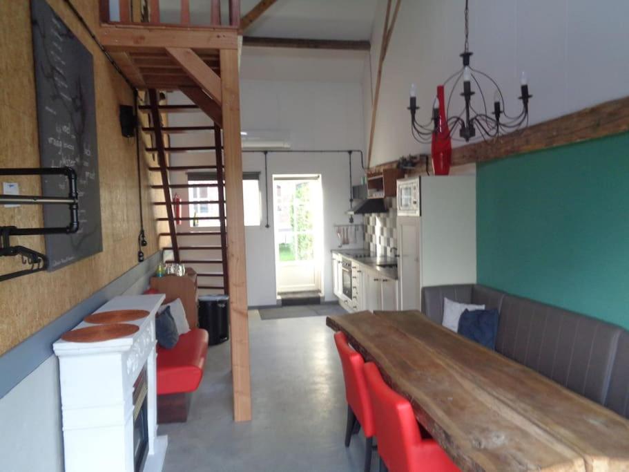 een keuken met een houten tafel en rode stoelen bij appartement met 5 slaapkamers in Moerstraten