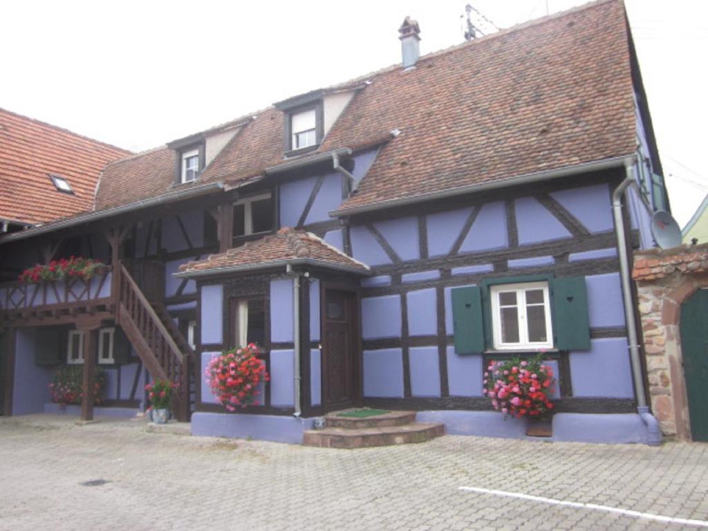 a blue and white building with flowers in front of it at Gite chez Marianne et Marcel in Ebersheim