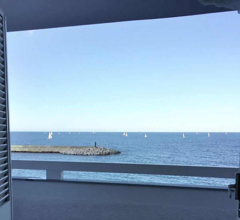 a view of the ocean from a window with sailboats at Fronte mare in Castelsardo