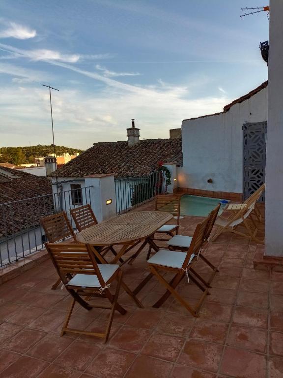a wooden table and chairs on a patio at Balcón de la Moreria con alberca in Constantina