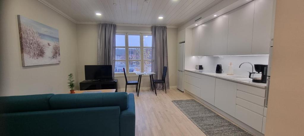 een woonkamer met een blauwe bank en een keuken bij Apartment Louna in Lahti