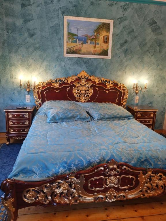a bedroom with a wooden bed with a blue comforter at Villa Imperia, Museums-Hotel in Blankenburg