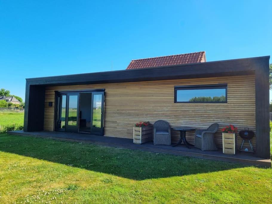 ein kleines Haus mit einem Tisch und zwei Stühlen in der Unterkunft Vakantiewoning 'De Eijk' in Doornspijk