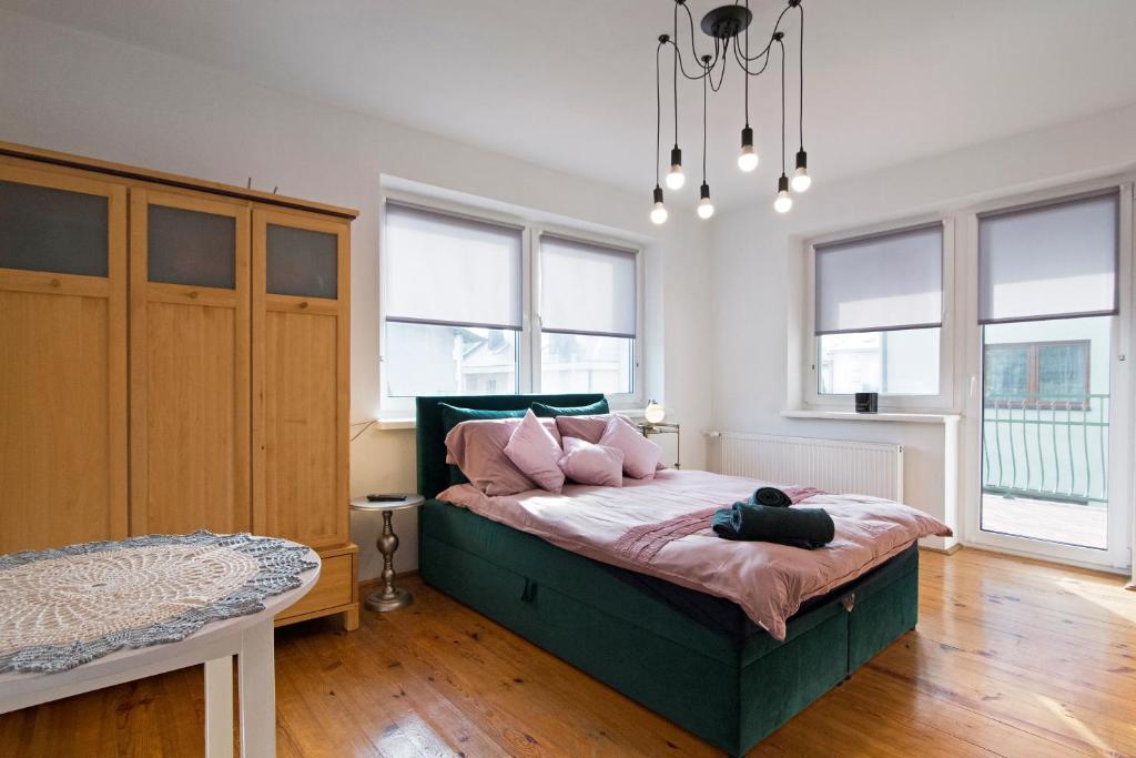 a bedroom with a bed with pink pillows on it at Apartament na Fatimskiej in Krakow