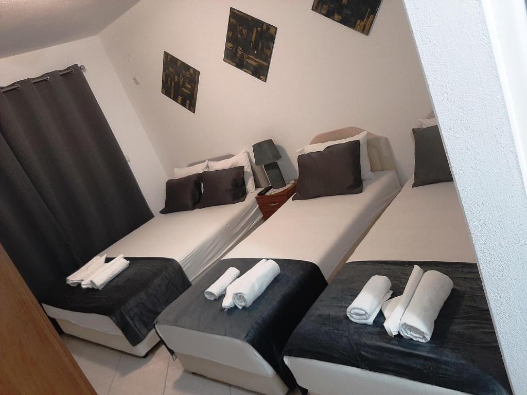 2 camas con almohadas blancas y negras en una habitación en Villa Alba Apartments, en Dobra Voda