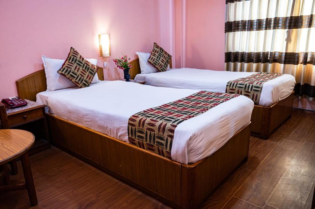 Postel nebo postele na pokoji v ubytování Kathmandu Prince Hotel