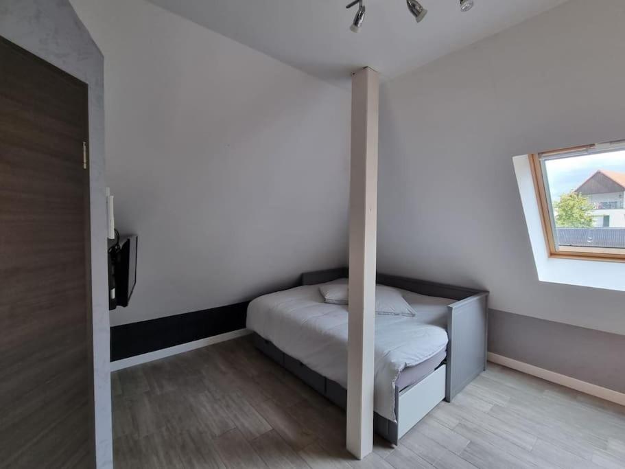 a small bedroom with a bed and a window at Studio de la Demi Lune in Plobsheim