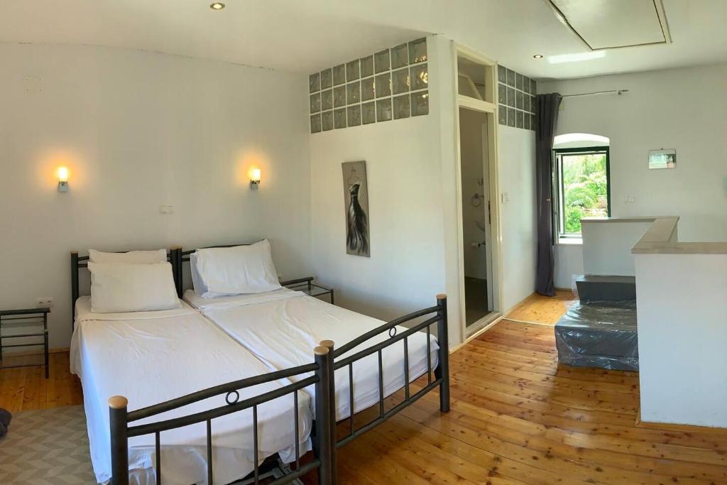 a bedroom with a large bed with white sheets at Picturesque Stonehouse in knockout Vrboska Hvar in Vrboska