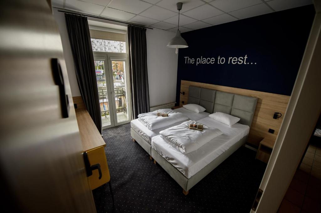 een slaapkamer met een bed met witte lakens bij ONRest Hostel Centrum Żytnia 8 in Kielce