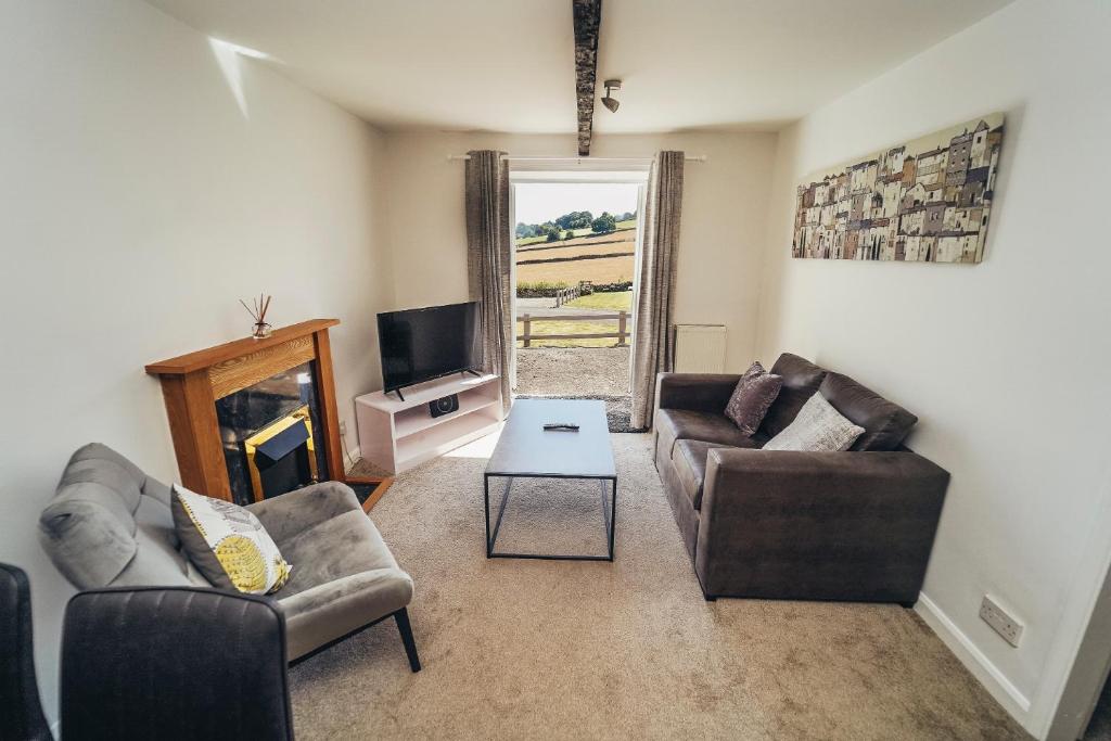 a living room with two couches and a tv at Cottages in Derbyshire - Orchard Cottage in Belper