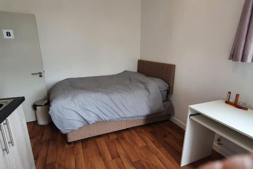 a small bedroom with a bed and a wooden floor at One bedroom studio apartment close to city centre in Sheffield