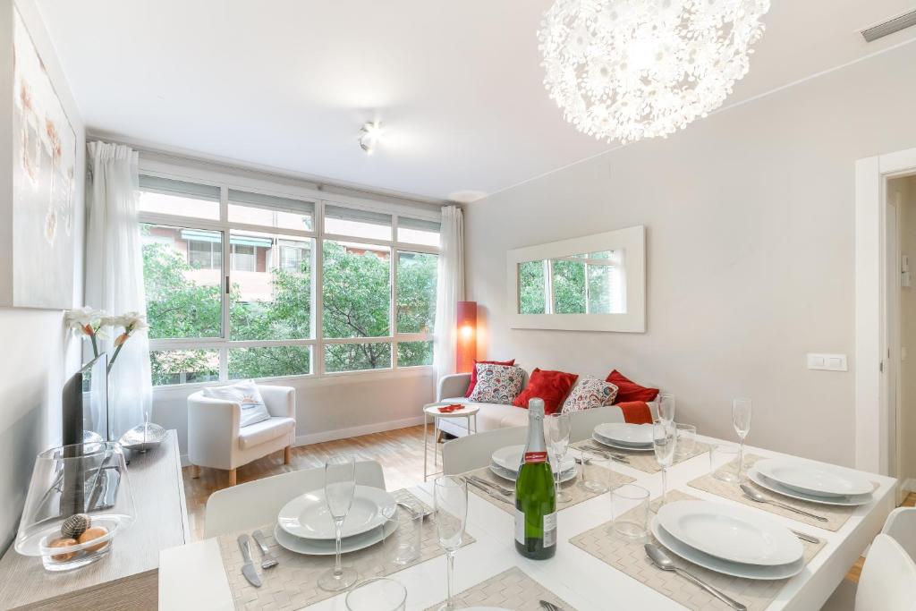 a white living room with a table and a couch at Elegance Barcelona Rentals in Barcelona