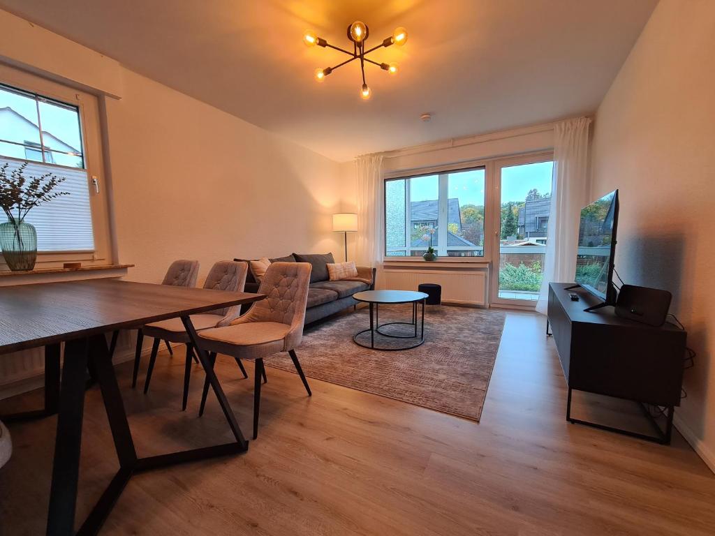 een woonkamer met een tafel en een bank bij 4-Zimmer-Ferienwohnung, modern, Küche, WLAN, Netflix in Castrop-Rauxel