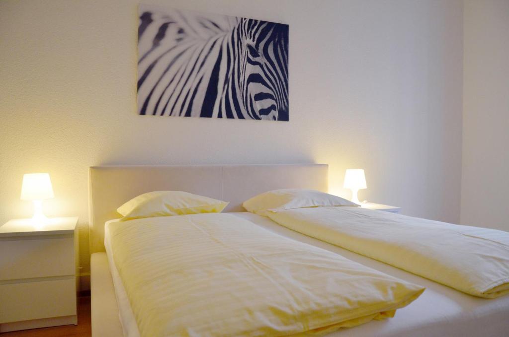 1 dormitorio con 1 cama con una foto de cebra en la pared en Rent a Home Landskronstrasse - Self Check-In en Basilea