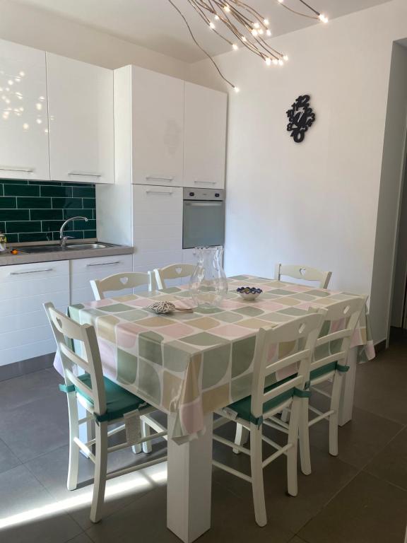 a kitchen with a table with chairs and a kitchen with white cabinets at IL QUADRIFOGLIO in Castellammare di Stabia