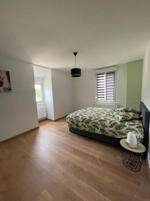 a bedroom with a bed and a table in it at Appartement Les Tilleuls &quot;3 étoiles&quot; in Niederbronn-les-Bains