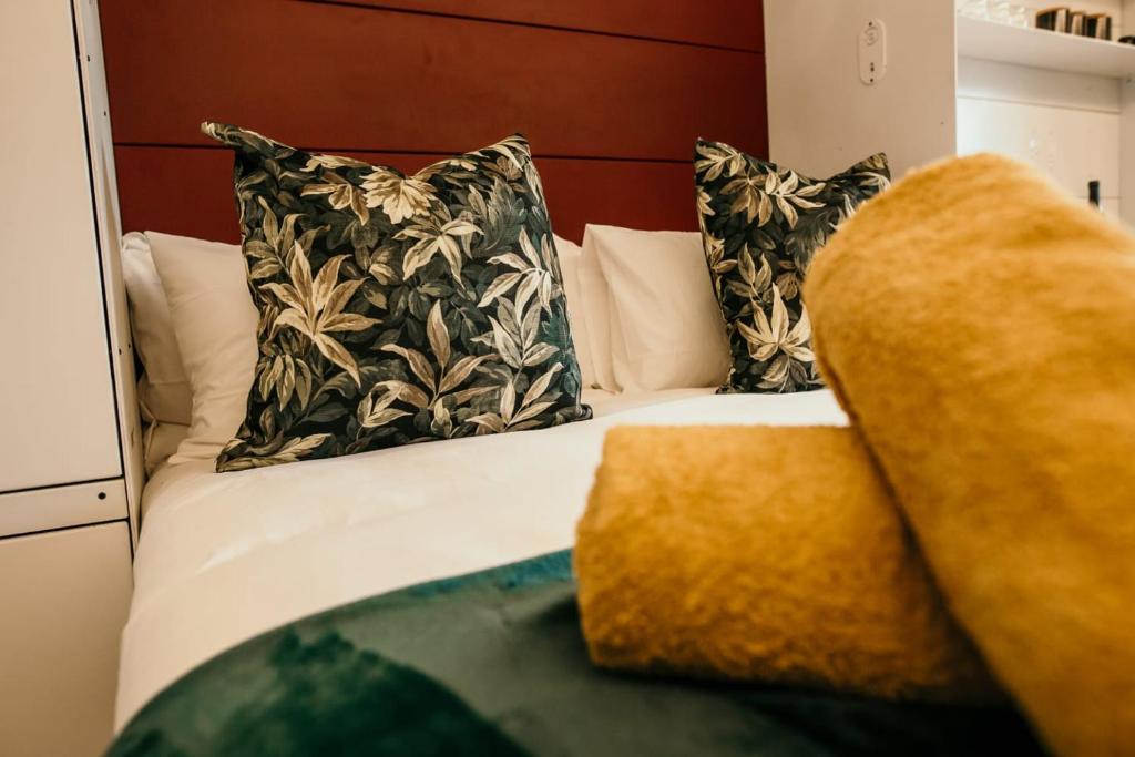 a bedroom with a bed with pillows at Uxolo Cape Town Living in Cape Town