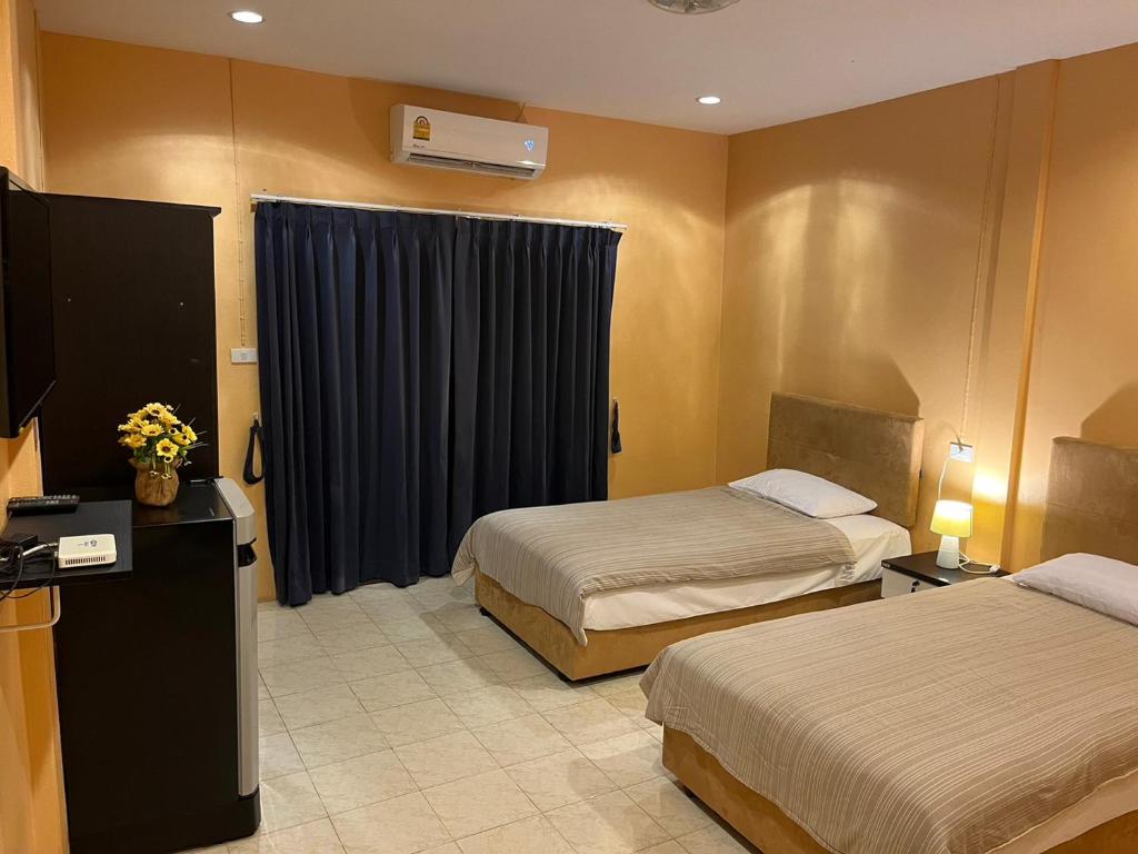 ein Hotelzimmer mit 2 Betten und einem TV in der Unterkunft Khaolak inn in Khao Lak
