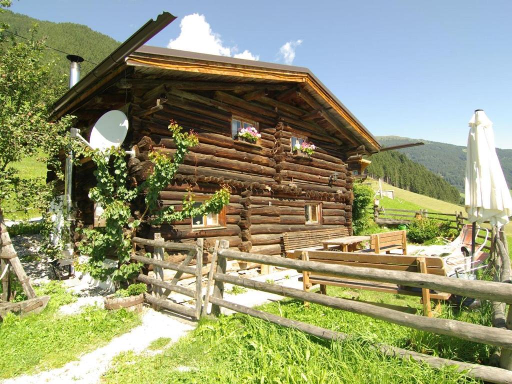 une cabane en rondins avec une clôture devant elle dans l'établissement Property in Hippach, à Hippach