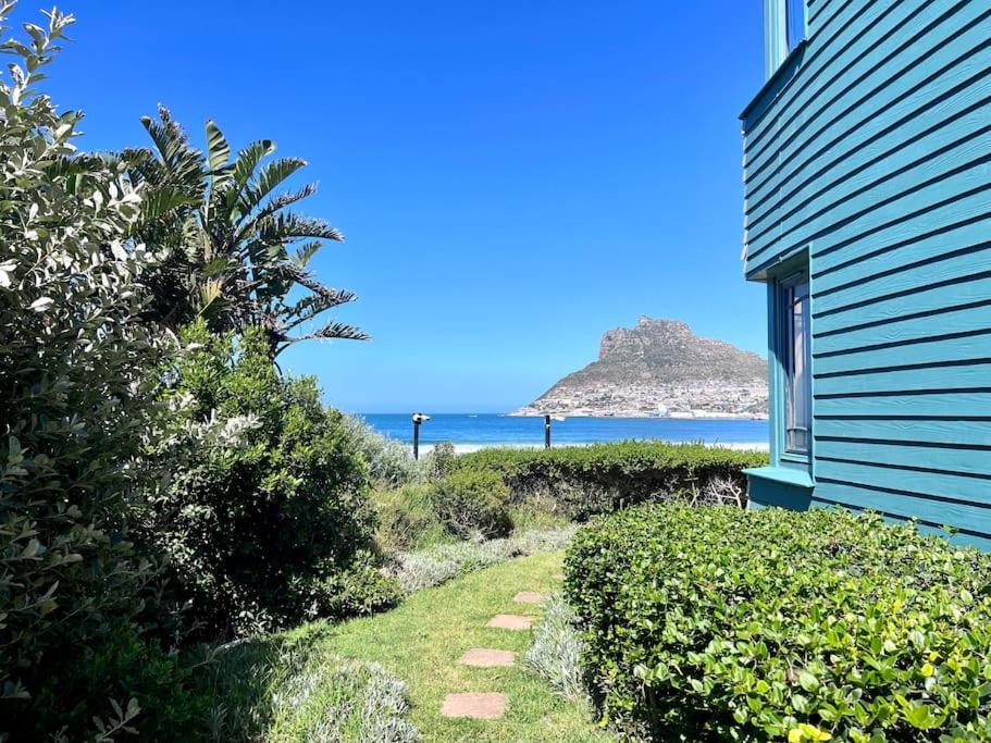 a house with a pathway leading to the ocean at Beautiful apartment across from the beach in Cape Town