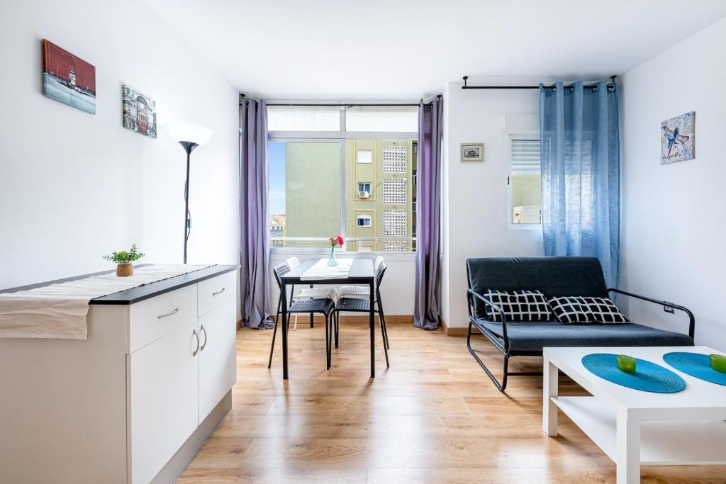 kuchnia i salon z kanapą i stołem w obiekcie Solaz-Andaluz City Center Apartment BY NAMASTE ELITE w mieście Torremolinos