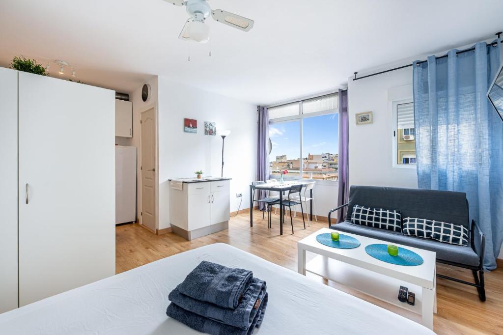 ein Schlafzimmer mit einem Bett, einem Sofa und einem Tisch in der Unterkunft Solaz-Andaluz City Center Apartment in Torremolinos