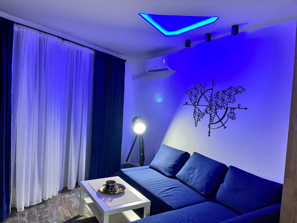 ein blaues Wohnzimmer mit einem Sofa und einem Tisch in der Unterkunft Diamond Magic Divcibare in Divčibare