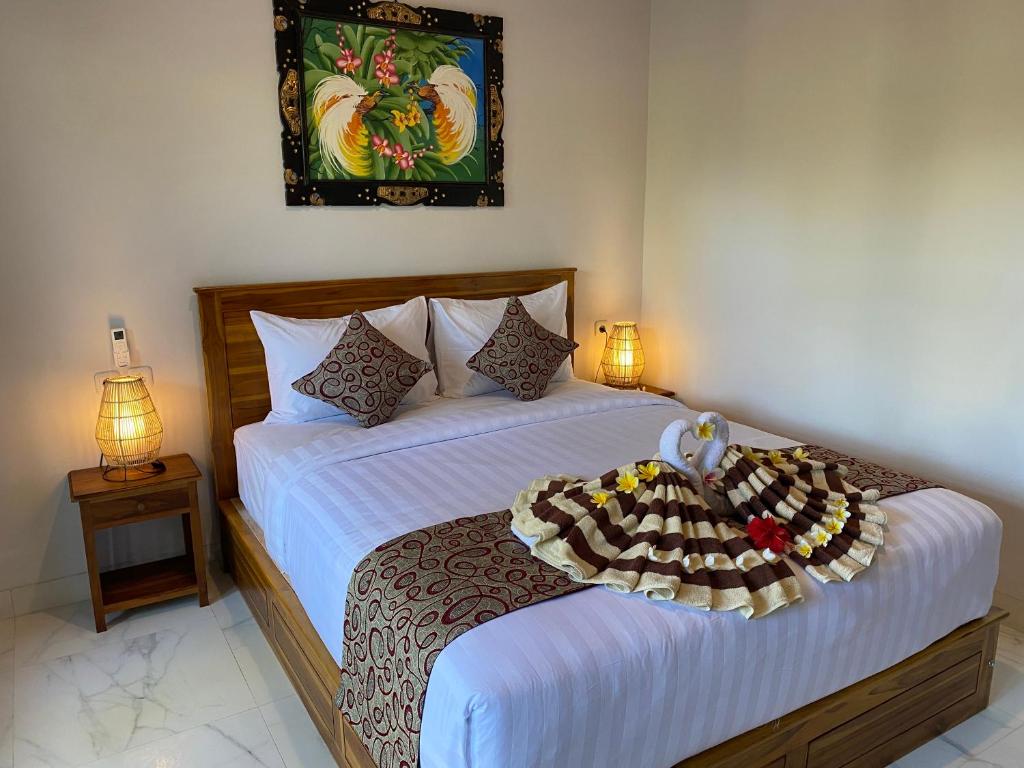 a bedroom with a bed with a tray of food on it at Pattri Dihati Lembongan in Nusa Lembongan