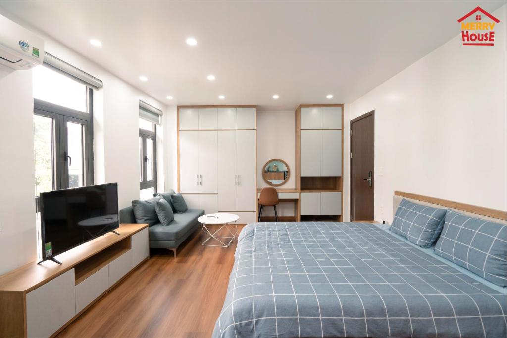 - une chambre avec un lit, une télévision et un canapé dans l'établissement Merry House Hoàng Huy Riverside, à Hai Phong