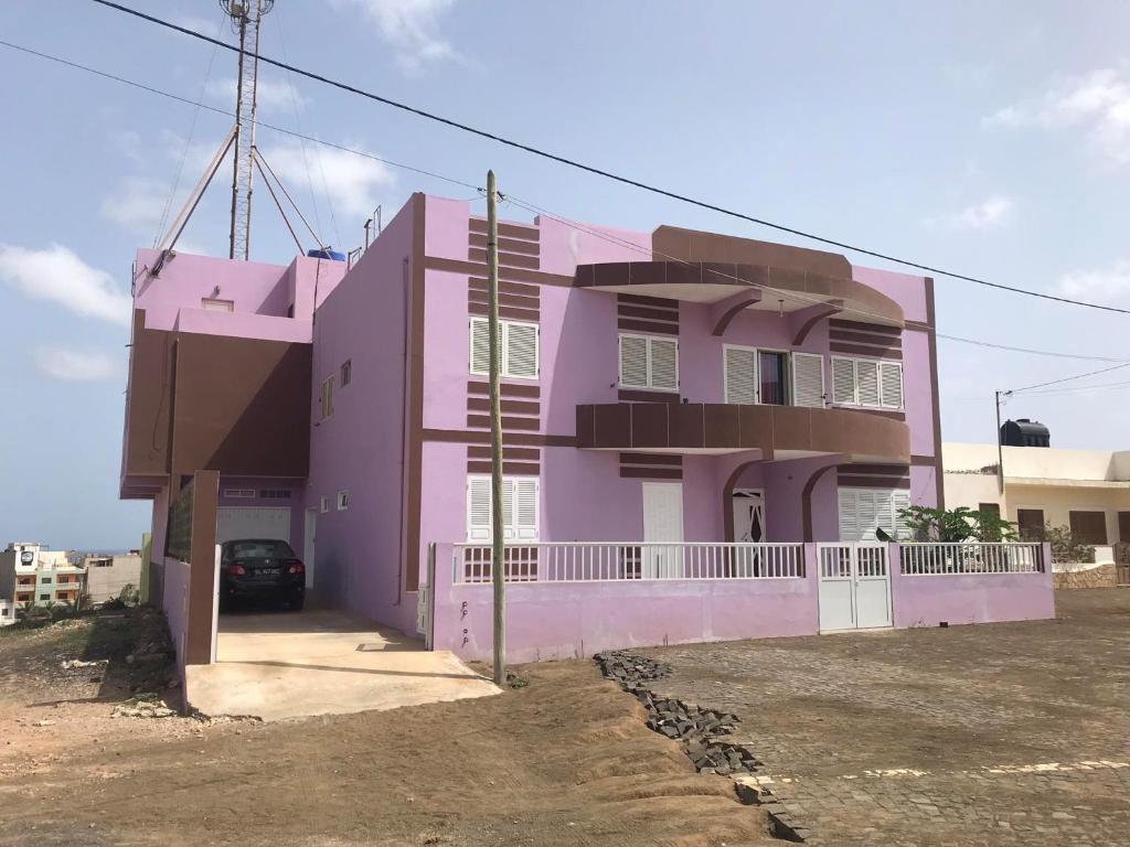 różowy dom z samochodem zaparkowanym przed nim w obiekcie CA FILO w Espargos