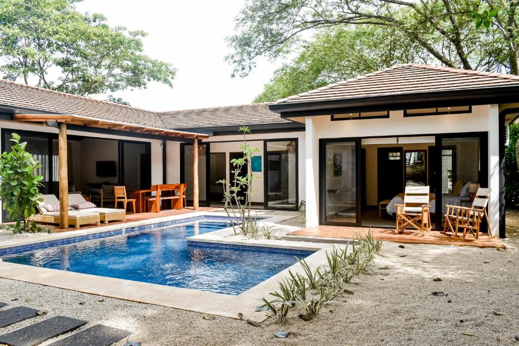 a house with a swimming pool in front of it at Calle 1 - 29 Tamarindo in Tamarindo